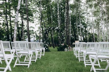 Açık hava düğün töreni için güzel çiçeklerle süslenmiş zarif kemer.       