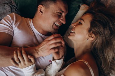 Mutlu çift birbirine aşık, sarılıyorlar ve yatakta birlikte yatıyorlar.