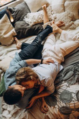 Mutlu çift sıcak bir stüdyoda yatakta uzanıyor. 