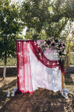 Açık hava düğün töreni için güzel çiçeklerle süslenmiş zarif kemer.       