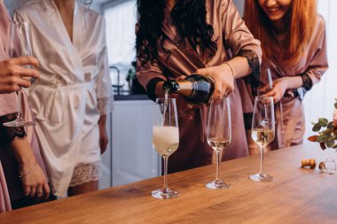 Şampanya kadehleri olan bir grup güzel genç arkadaş. Gelin ve nedimeler