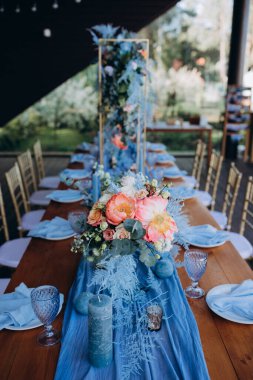 Restoranda çiçeklerle süslenmiş zarif bir düğün masası.                                