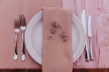 Düğün için hazırlanmış bir masa ya da pembe renkli başka bir yemek servisi.