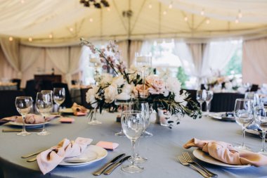 Restoranda çiçeklerle süslenmiş zarif bir düğün masası.                                