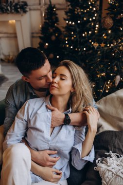 Genç çift yatakta yatıyor, stüdyo Noel dekoruyla 