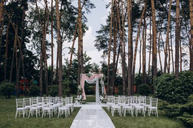 Açık hava düğün töreni için güzel çiçeklerle süslenmiş zarif kemer.       