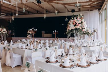 Restoranda çiçeklerle süslenmiş zarif bir düğün masası.                                