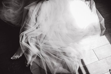 Gelinin düşük kesimi güzel gelinlik içinde yerde, siyah beyaz 