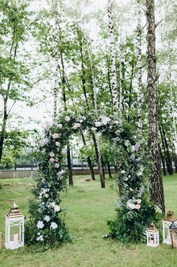 Açık hava düğün töreni için güzel çiçeklerle süslenmiş zarif kemer.       