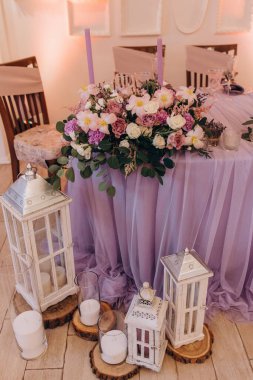 Düğün resepsiyonunda çiçeklerle süslenmiş zarif sofra manzarası.         