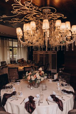 Restoranda çiçeklerle süslenmiş zarif bir düğün masası.                                