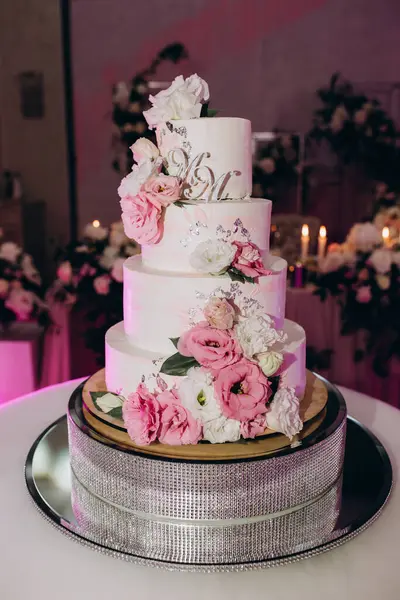 Çiçeklerle süslenmiş lezzetli düğün pastasının yakın çekimi.              