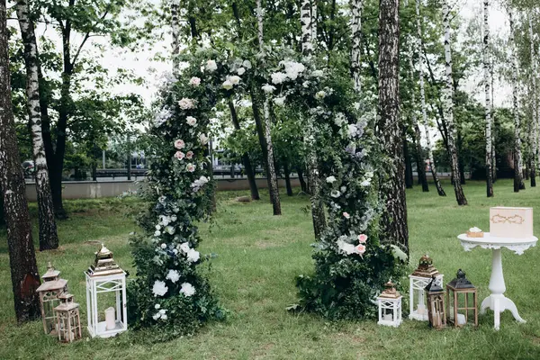 Açık hava düğün töreni için güzel çiçeklerle süslenmiş zarif kemer.       