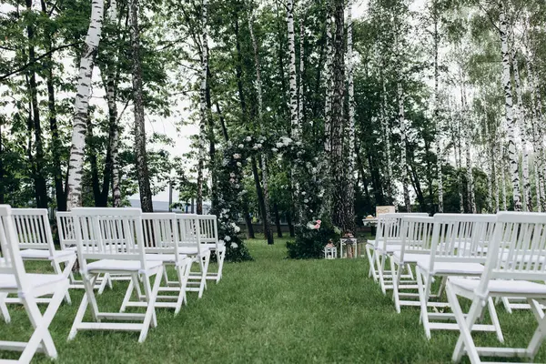 Açık hava düğün töreni için güzel çiçeklerle süslenmiş zarif kemer.       