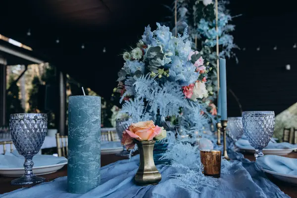 Düğün resepsiyonunda çiçeklerle süslenmiş zarif sofra manzarası.         