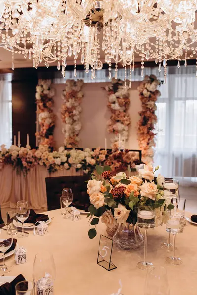 Restoranda çiçeklerle süslenmiş zarif bir düğün masası.                                