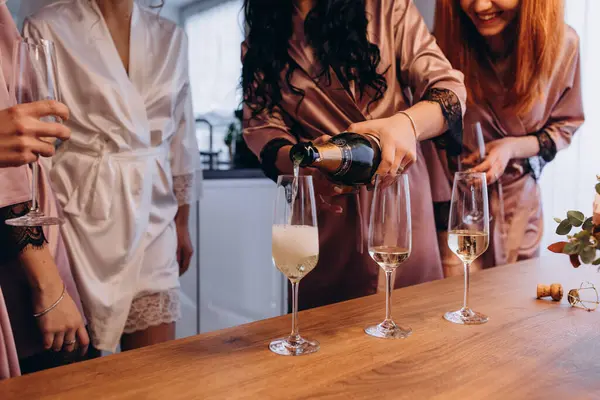 Şampanya kadehleri olan bir grup güzel genç arkadaş. Gelin ve nedimeler