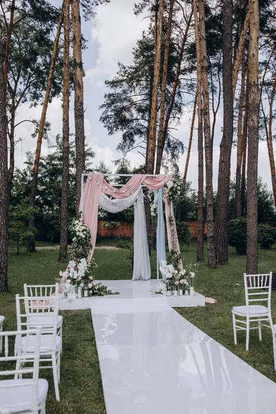 Açık hava düğün töreni için güzel çiçeklerle süslenmiş zarif kemer.       