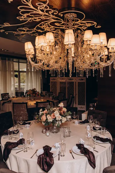 Restoranda çiçeklerle süslenmiş zarif bir düğün masası.                                