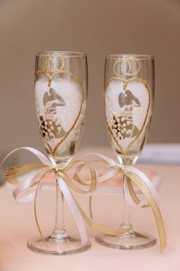 Kurdeleli ve fiyonklu iki şampanya kadehinin yakın görüntüsü.