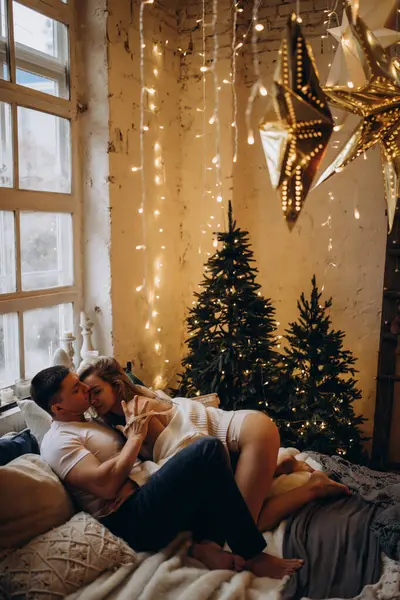 Mutlu genç çift Noel zamanı yatak odasında birbirine aşık.        