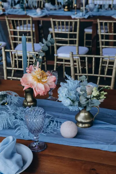 Düğün resepsiyonunda çiçeklerle süslenmiş zarif sofra manzarası.         