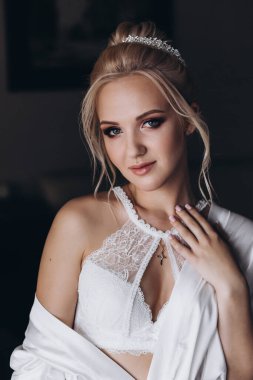 Güzel, genç, mutlu bir gelinin portresi beyaz iç çamaşırlı, sabah zarif saç stili.              