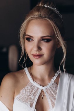 Güzel, genç, mutlu bir gelinin portresi beyaz iç çamaşırlı, sabah zarif saç stili.              