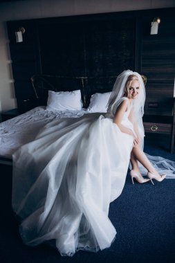 Güzel genç gelin düğün sabahı yatak odasında.       