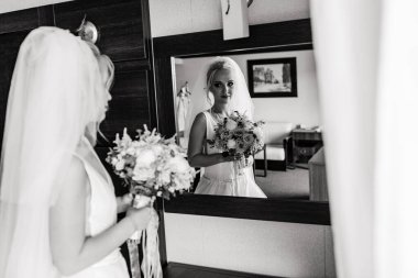 Odada buketle poz veren güzel sarışın gelinin tek renkli görüntüsü