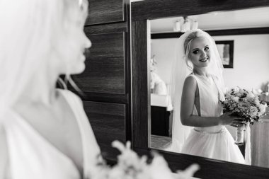 Odada buketle poz veren güzel sarışın gelinin tek renkli görüntüsü