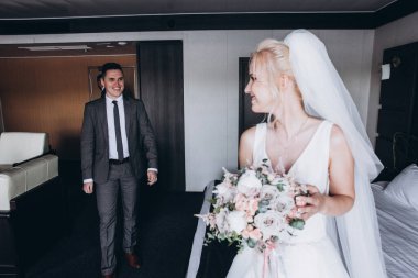 Mutlu genç gelin ve damat içeride gülümsüyor.