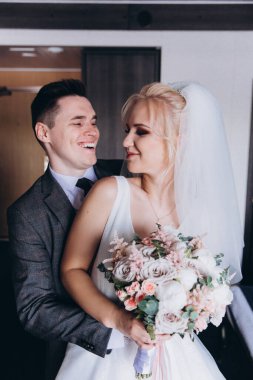 Mutlu gelin ve damat düğün günü sarılıyor.