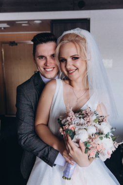 Mutlu gelin ve damat düğün günü sarılıyor.