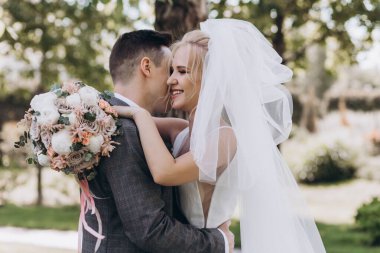 Güzel, mutlu, genç bir çift parkta birbirlerine sarılıp poz veriyorlar.                     