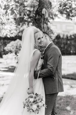 Güzel, mutlu, genç bir çift parkta birbirlerine sarılıp poz veriyorlar.                     