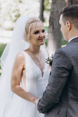 Güzel, mutlu, genç bir çift parkta el ele tutuşuyor.          