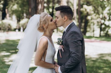 Güzel, mutlu genç bir çift parkta öpüşüyor.          