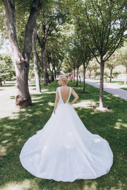 Park 'ta koşan gelinlikli güzel gelinin arka manzarası. 