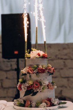 Çiçeklerle süslenmiş lezzetli düğün pastasının yakın plan görüntüsü 