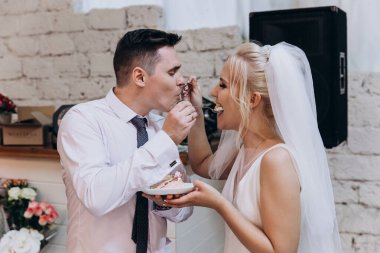 Mutlu gelin ve damat düğün günü pasta yiyorlar.