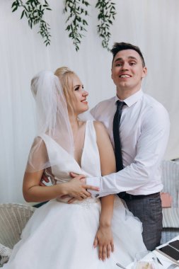 Mutlu gelin ve damat düğün günü sarılıyor.