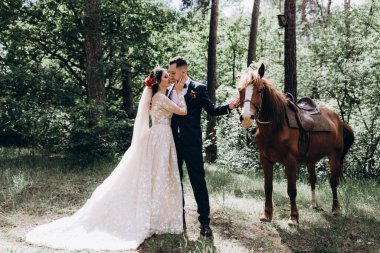 Ormanda atı olan mutlu gelin ve damat.               