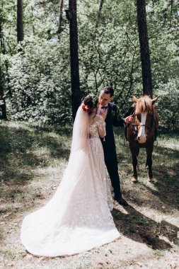 Ormanda atı olan mutlu gelin ve damat.               