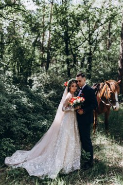 Ormanda atı olan mutlu gelin ve damat.               