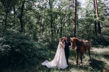 Ormanda atı olan mutlu gelin ve damat.               