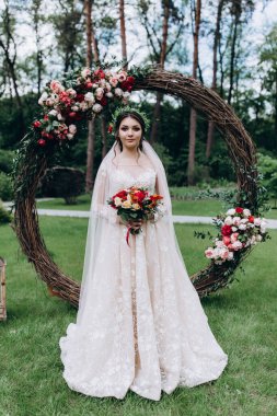 Bir düğün parkında çiçek çelenginde güzel bir gelin. düğün töreni.