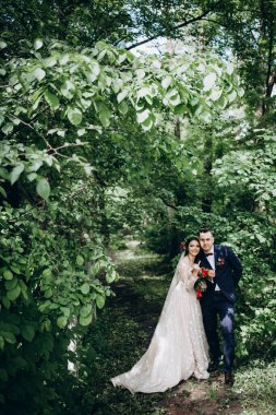 Mutlu evlilik çifti çam ağaçlarının yanında poz veriyor. düğün günü.