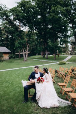 Gelin ve damat parkta sandalyede 