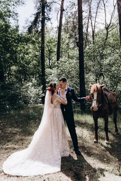 Ormanda atı olan mutlu gelin ve damat.               